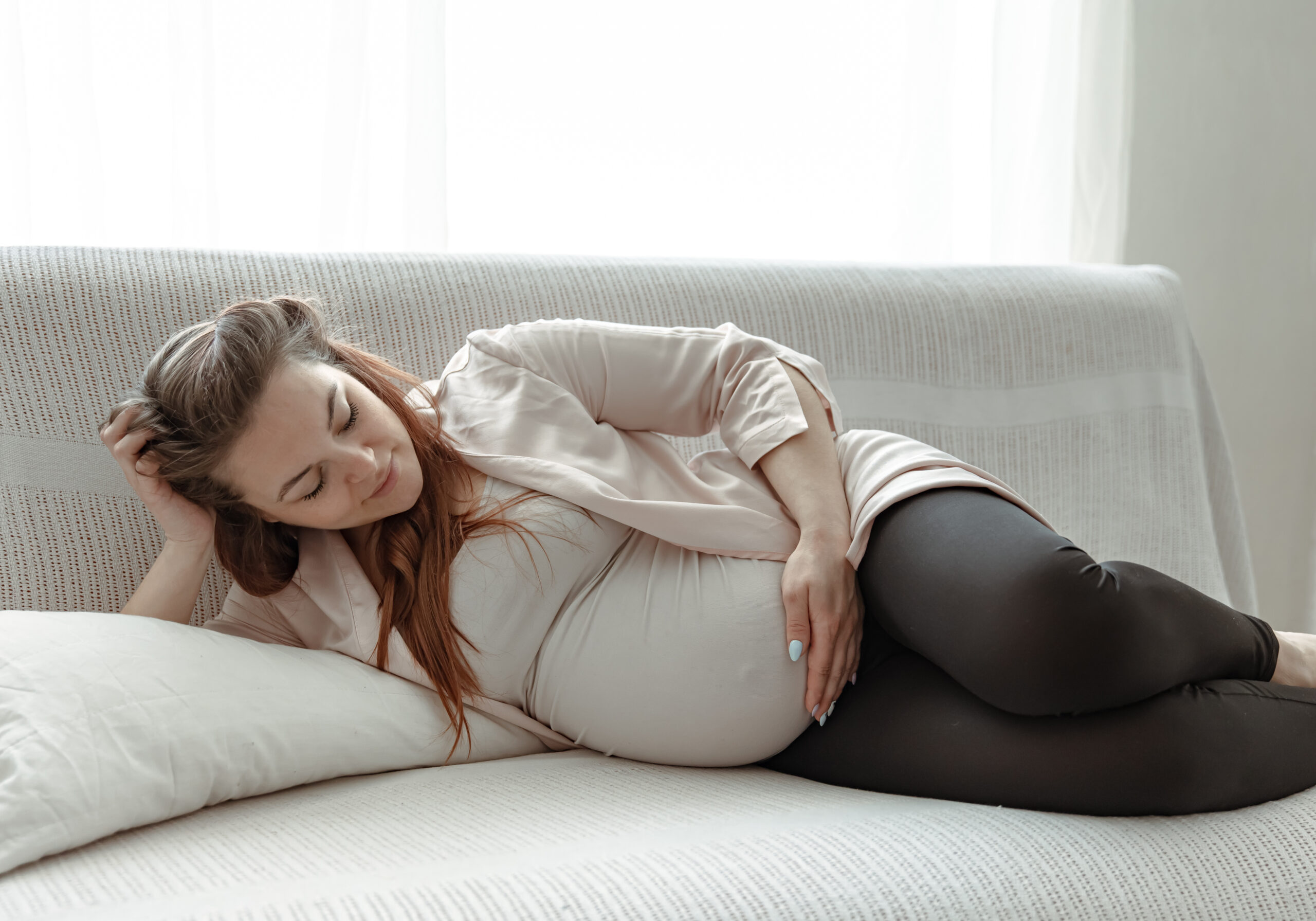 a young pregnant woman is lying on the sofa in the 2021 09 02 20 16 11 utc scaled