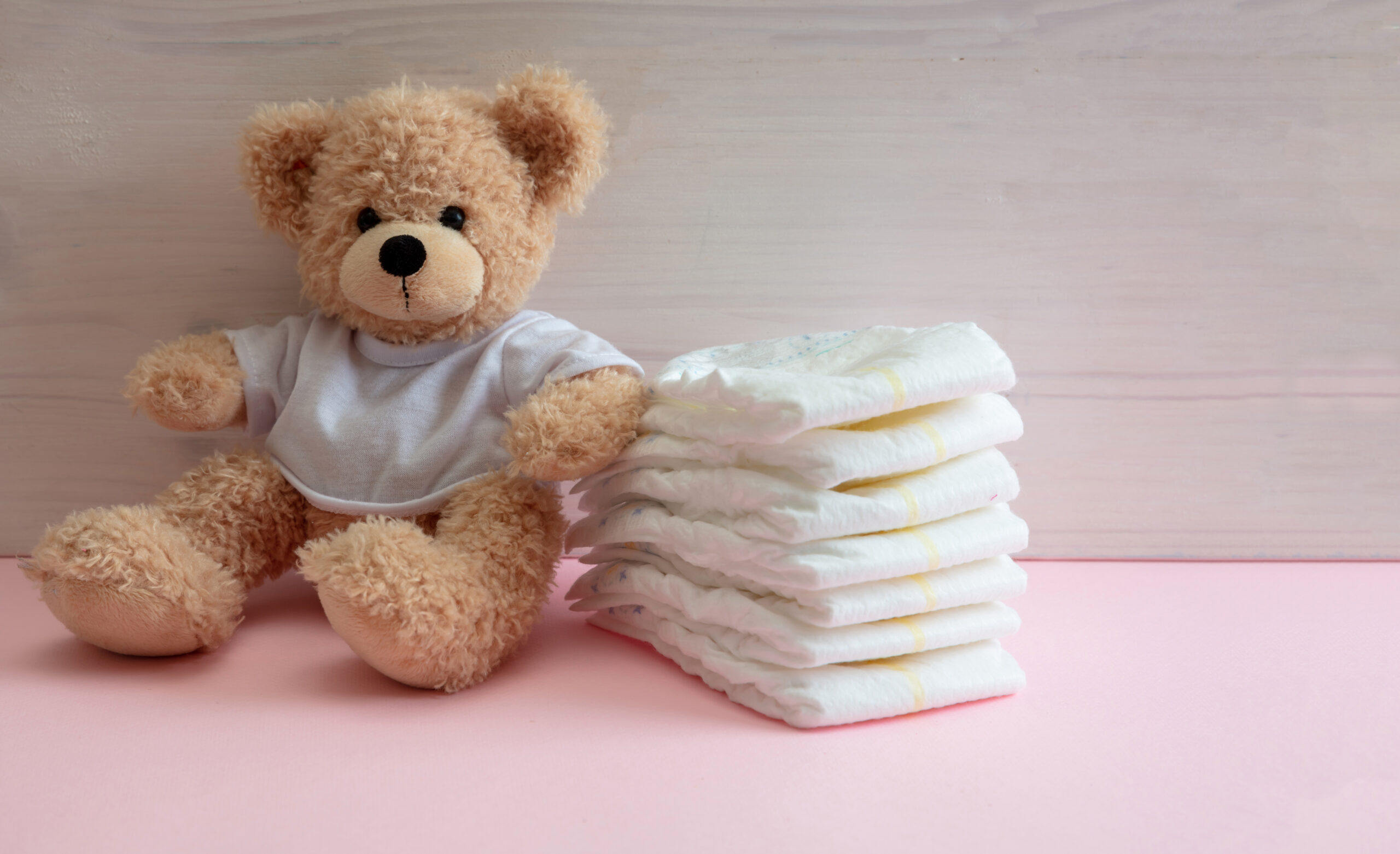 baby girl diapers teddy sitting on pink color flo 2022 12 16 12 23 06 utc scaled